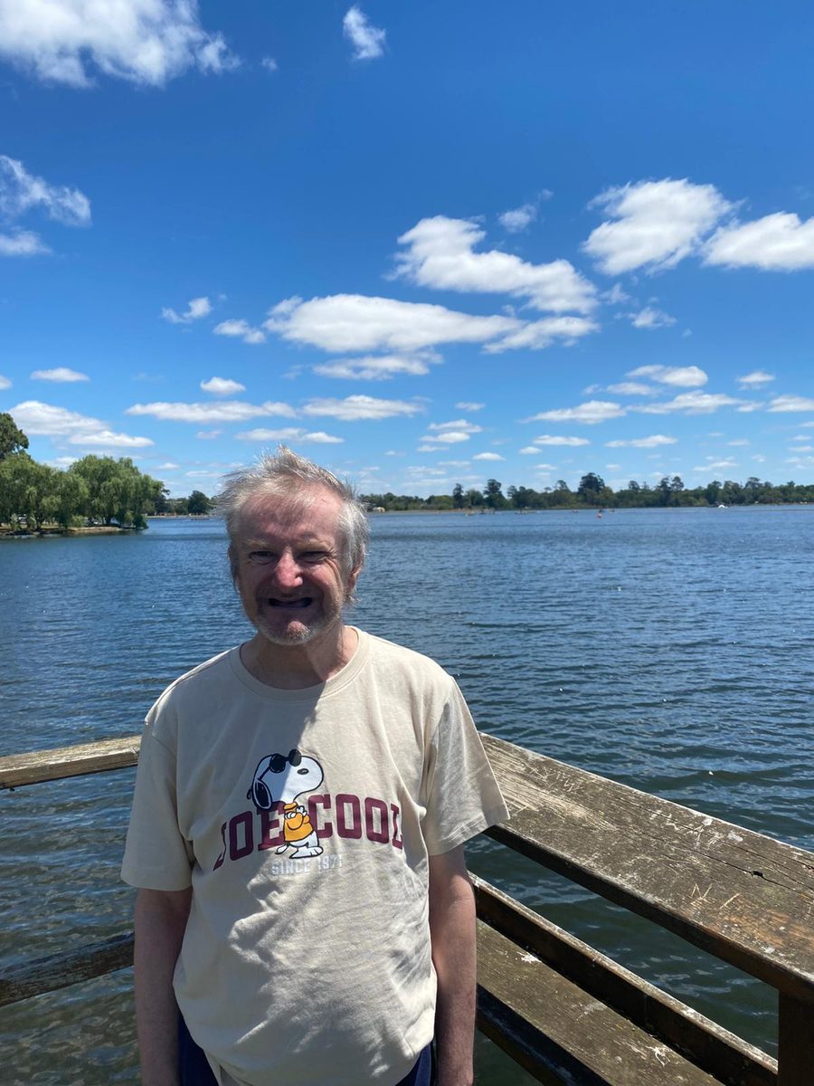 A resident smiling by the lake on an outing