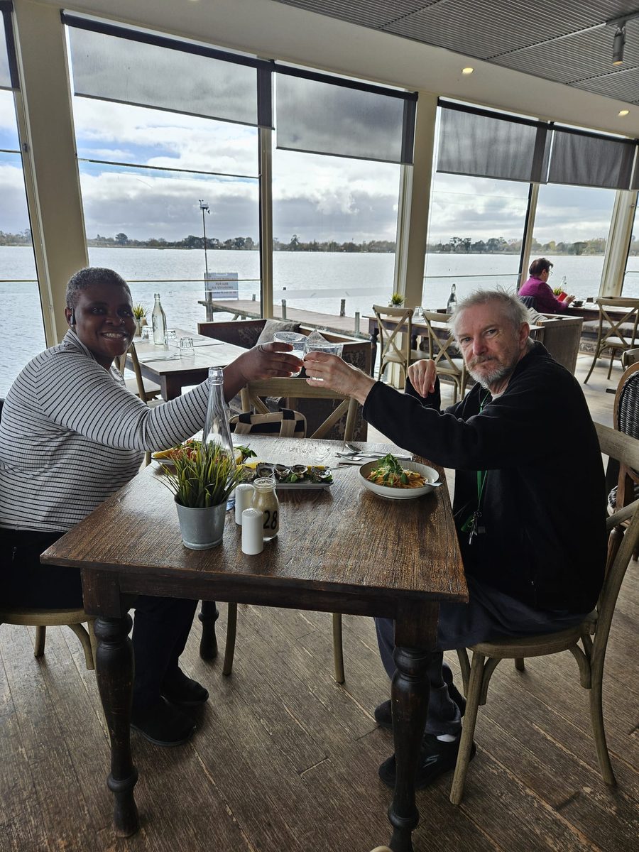 A support partner and resident sharing a meal out