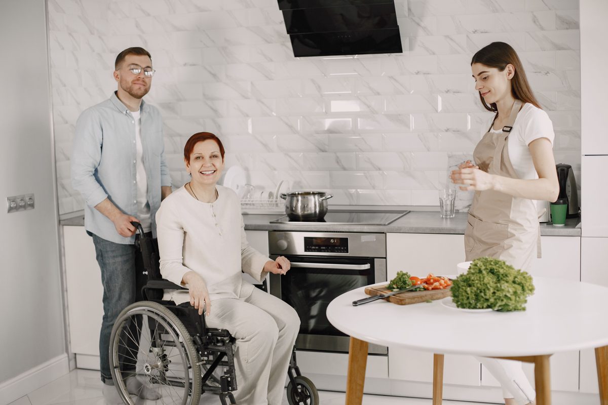 Support workers with a resident in a home kitchen