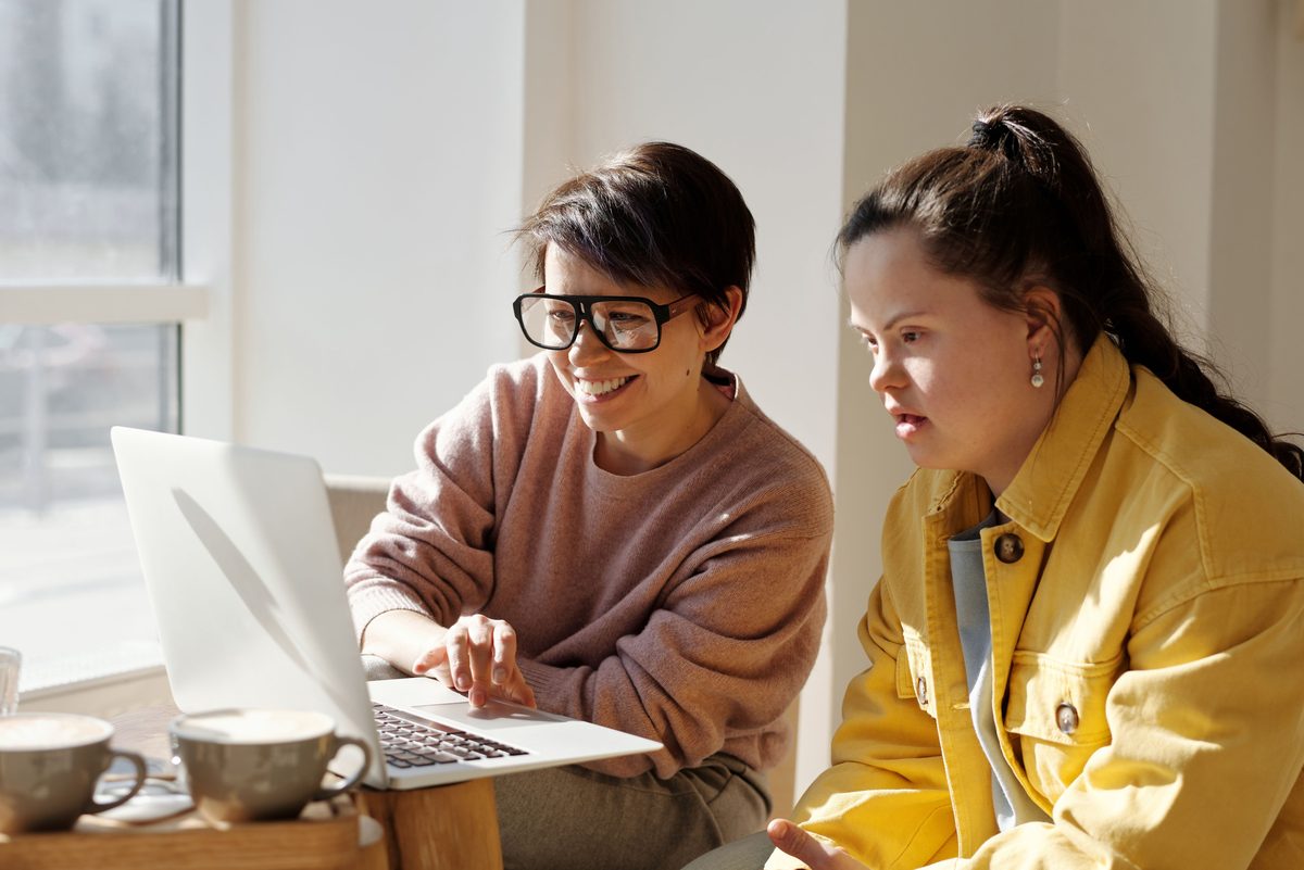Support worker and young woman working together on a laptop